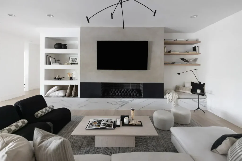 Modern monochrome living room with fireplace, TV, and built-in shelves