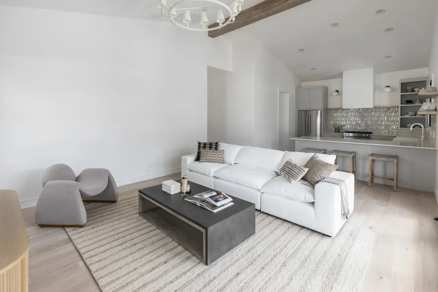 Modern open-concept living room with white sofa and kitchen