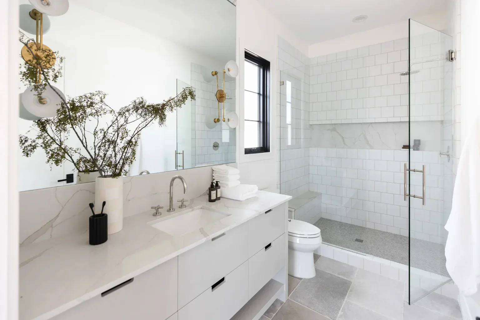 Modern white bathroom with marble vanity and glass shower