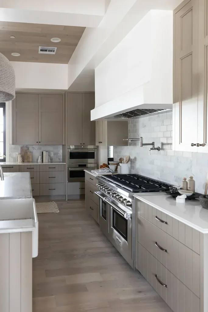 Modern kitchen with gray cabinets, stainless steel range, marble backsplash