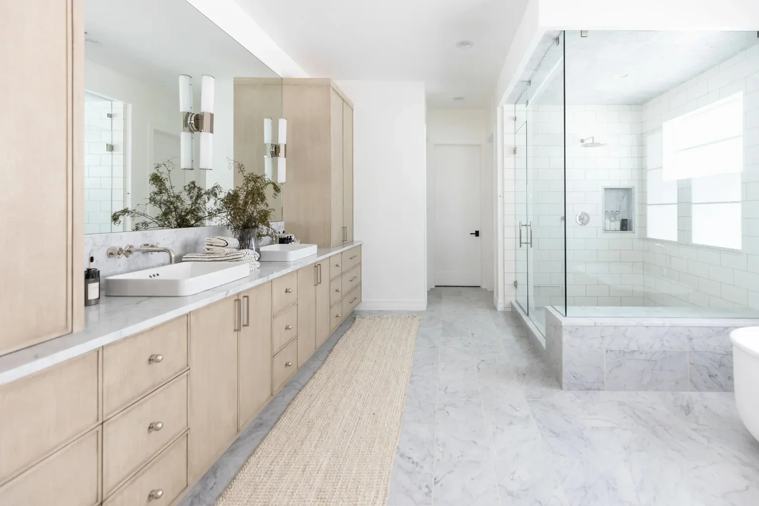 Luxurious master bathroom with marble floors and glass shower