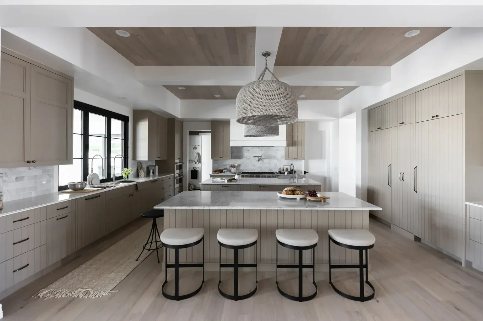 Modern neutral kitchen with large island and woven pendant light