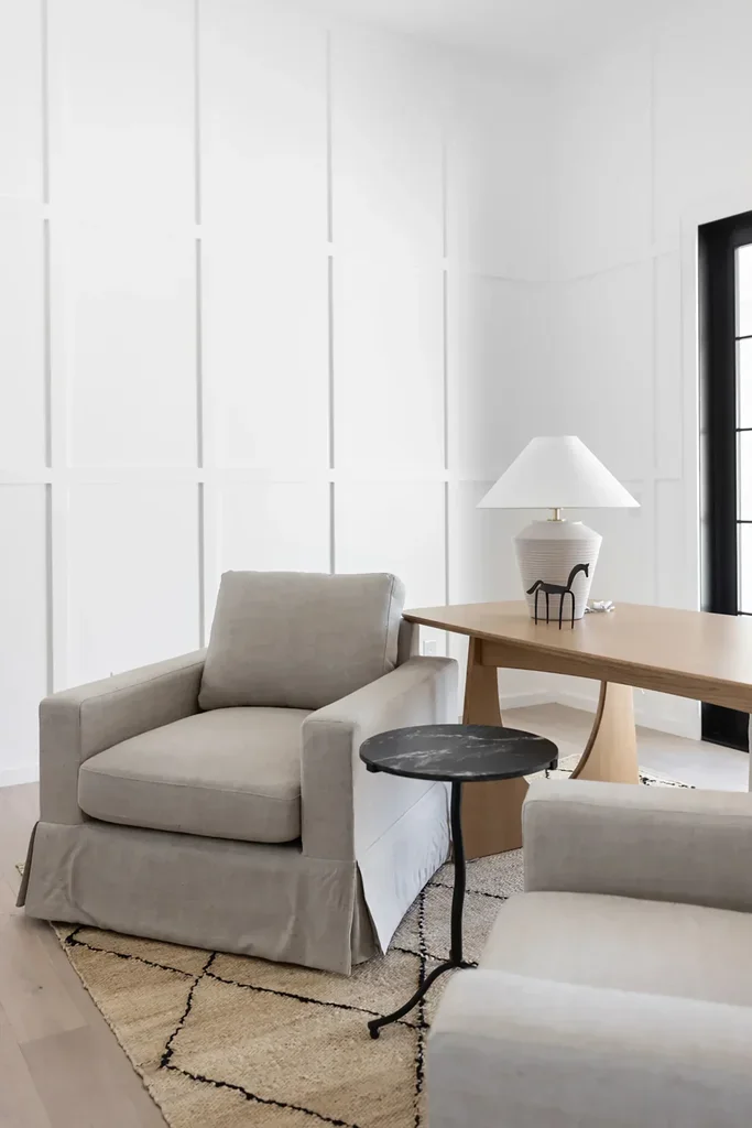 Modern minimalist living room with neutral armchair and wood desk