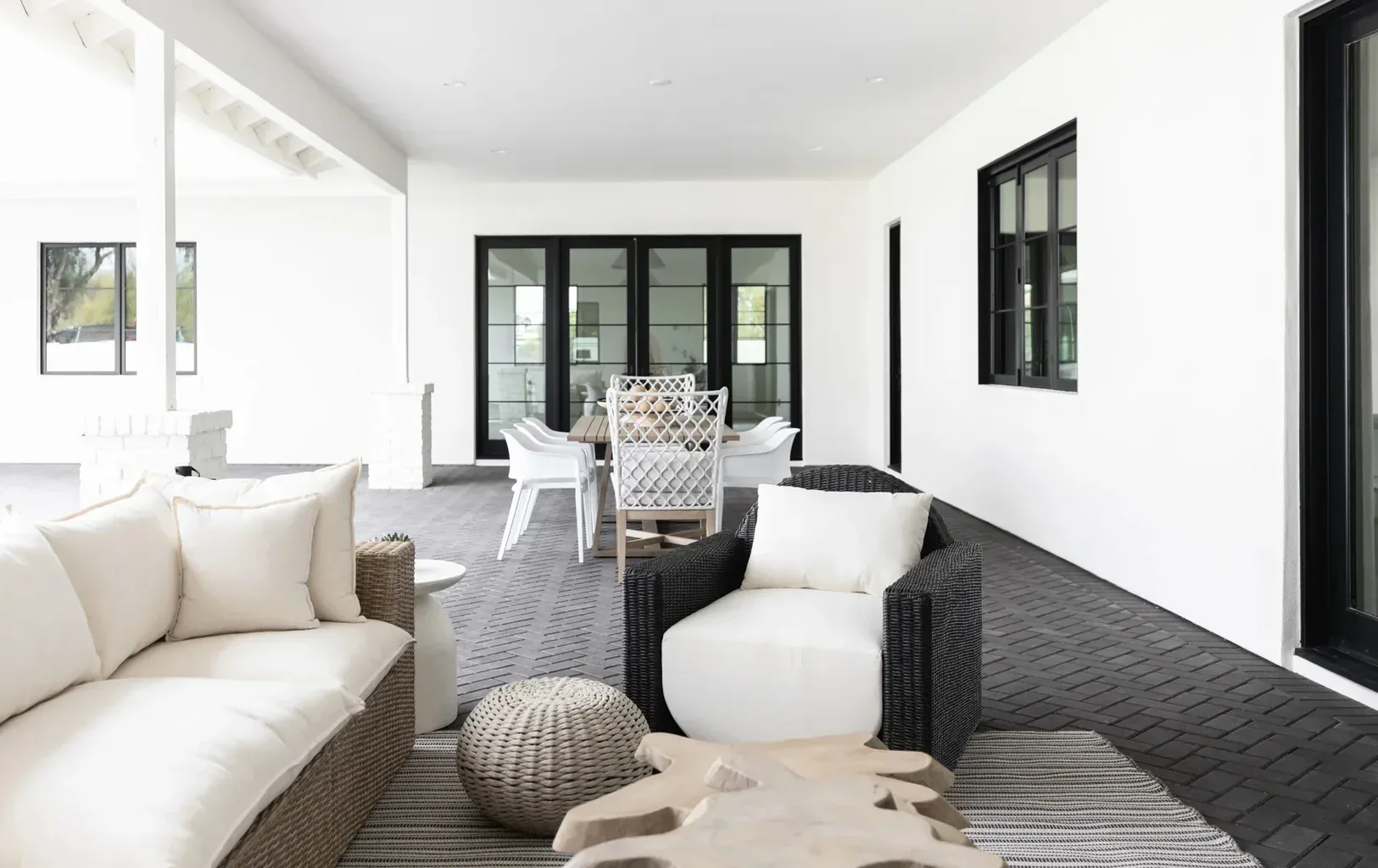 Modern covered patio with wicker furniture and white cushions