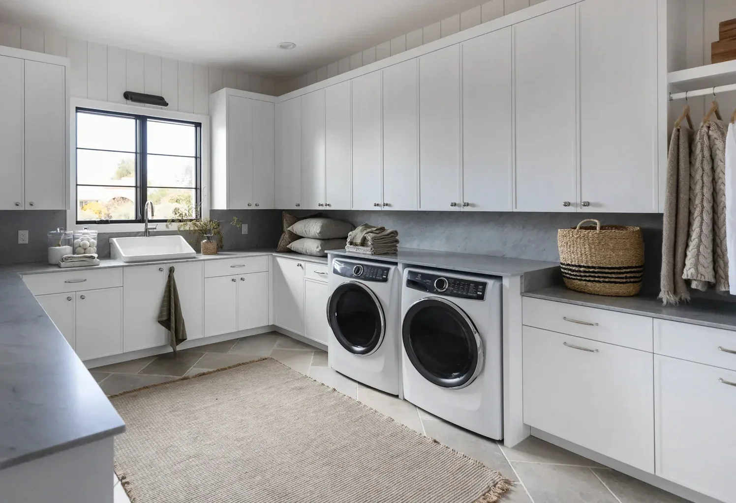Modern laundry room with white cabinets and front-load washer dryer