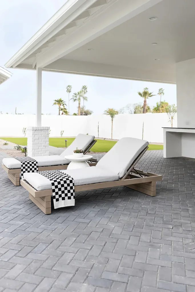 Two outdoor lounge chairs with checkered towels on patio