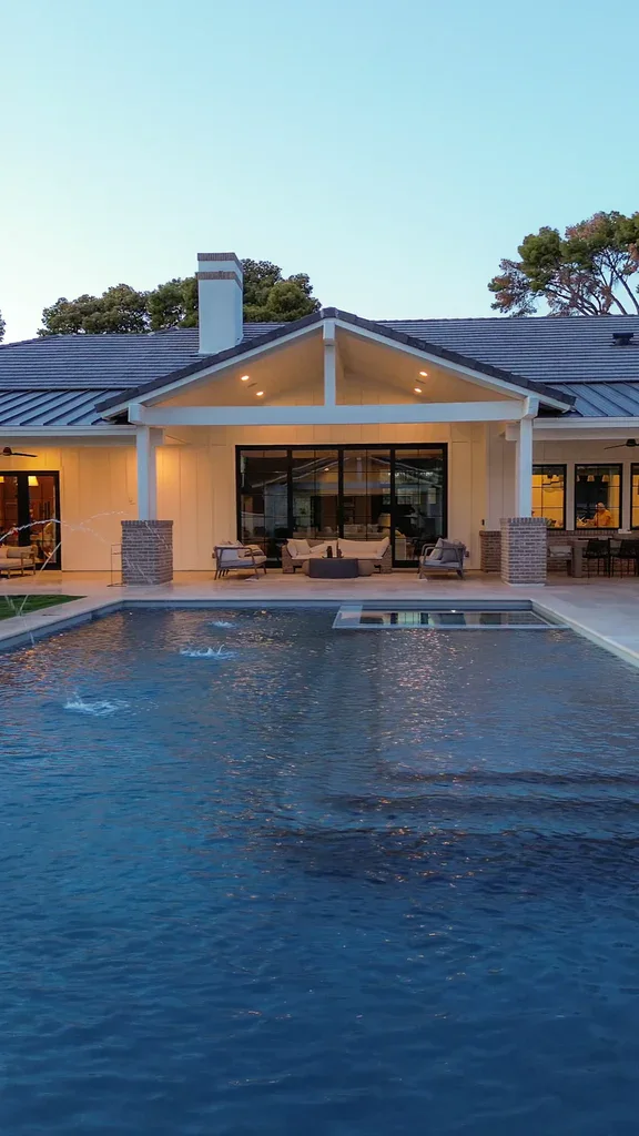 Luxury home with large backyard pool at dusk