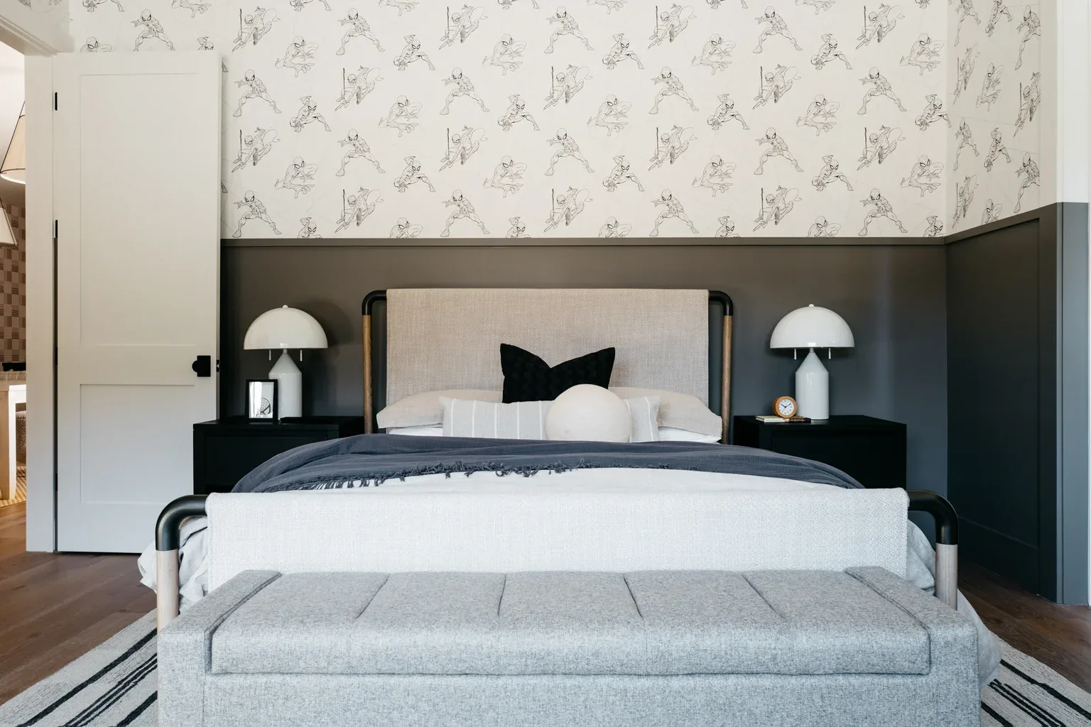 Modern bedroom with superhero wallpaper, upholstered bed, and nightstands