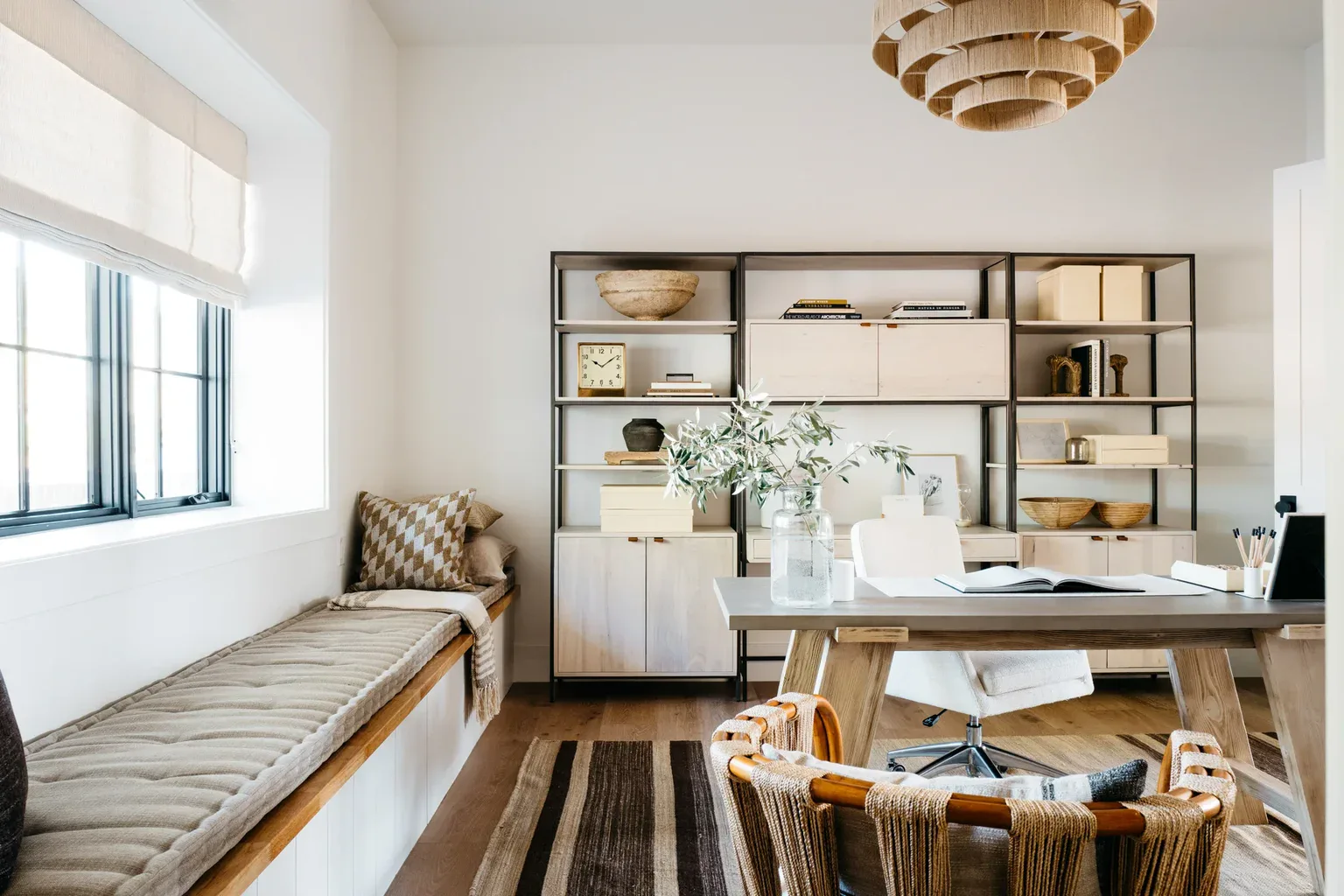 Modern neutral home office with shelving, desk, and window seat