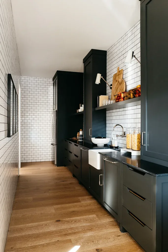 Modern black kitchen pantry with white subway tile walls