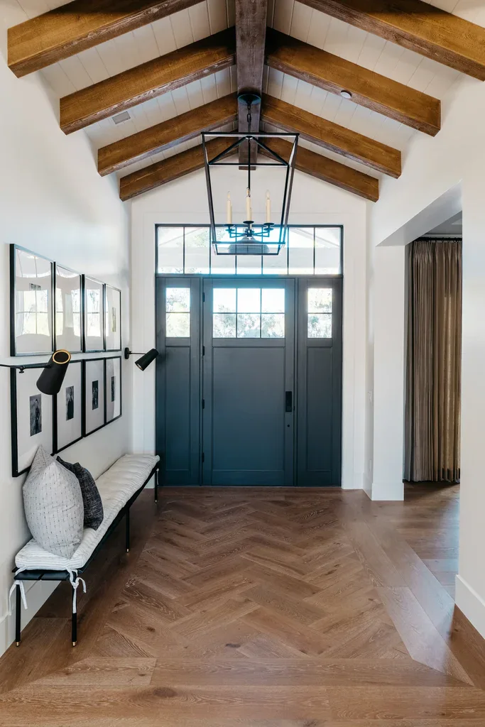 Elegant entryway with vaulted beamed ceiling and herringbone floors