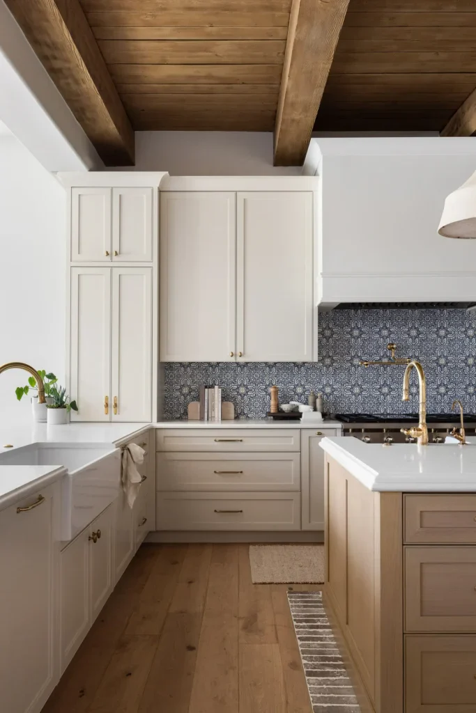 Elegant kitchen with white cabinets, blue tile backsplash, wood beams