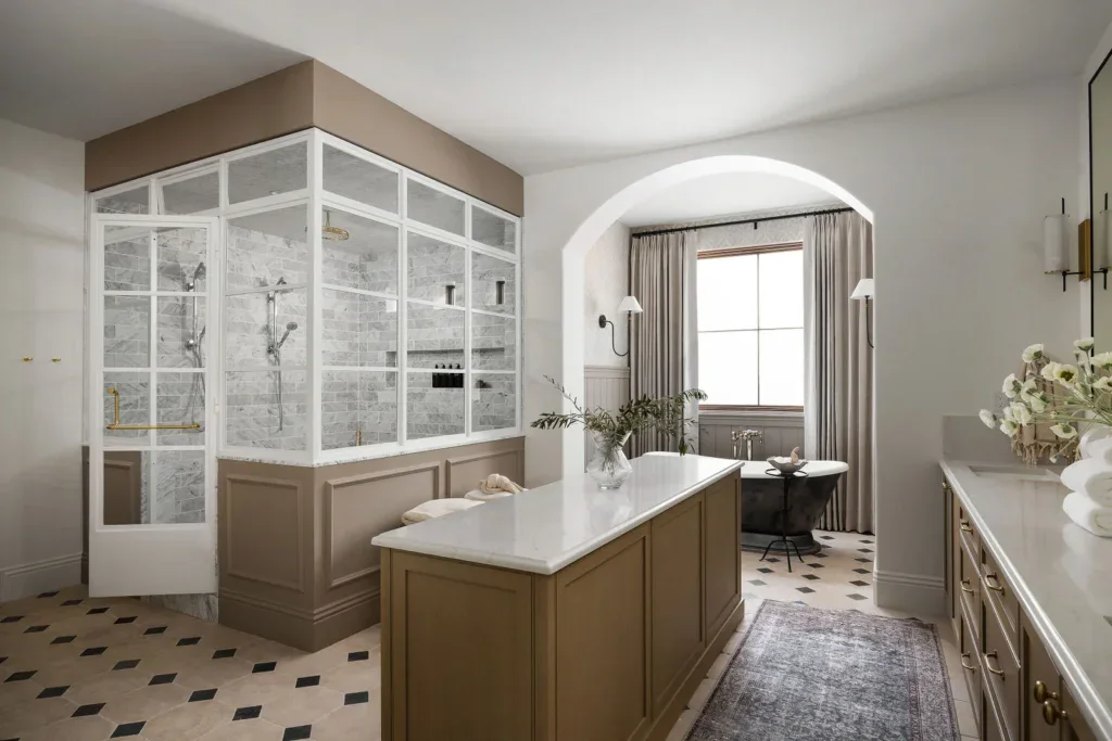 Elegant luxury bathroom with glass shower, clawfoot tub, arched alcove