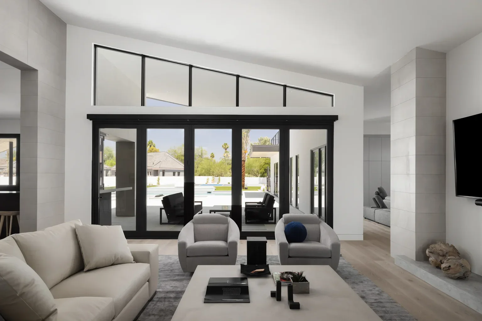 Modern living room with floor-to-ceiling windows overlooking pool