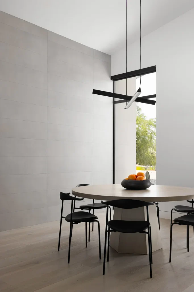 Minimalist dining room with round table and black chairs