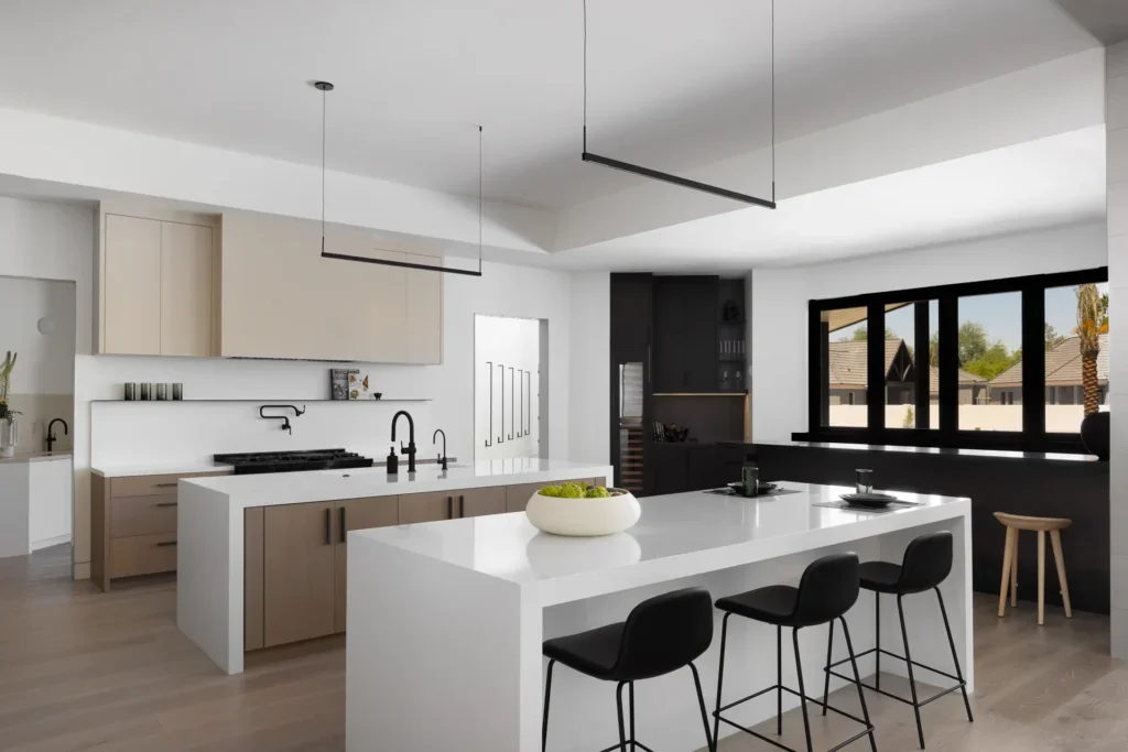 Modern kitchen with white island, black stools, and neutral cabinets