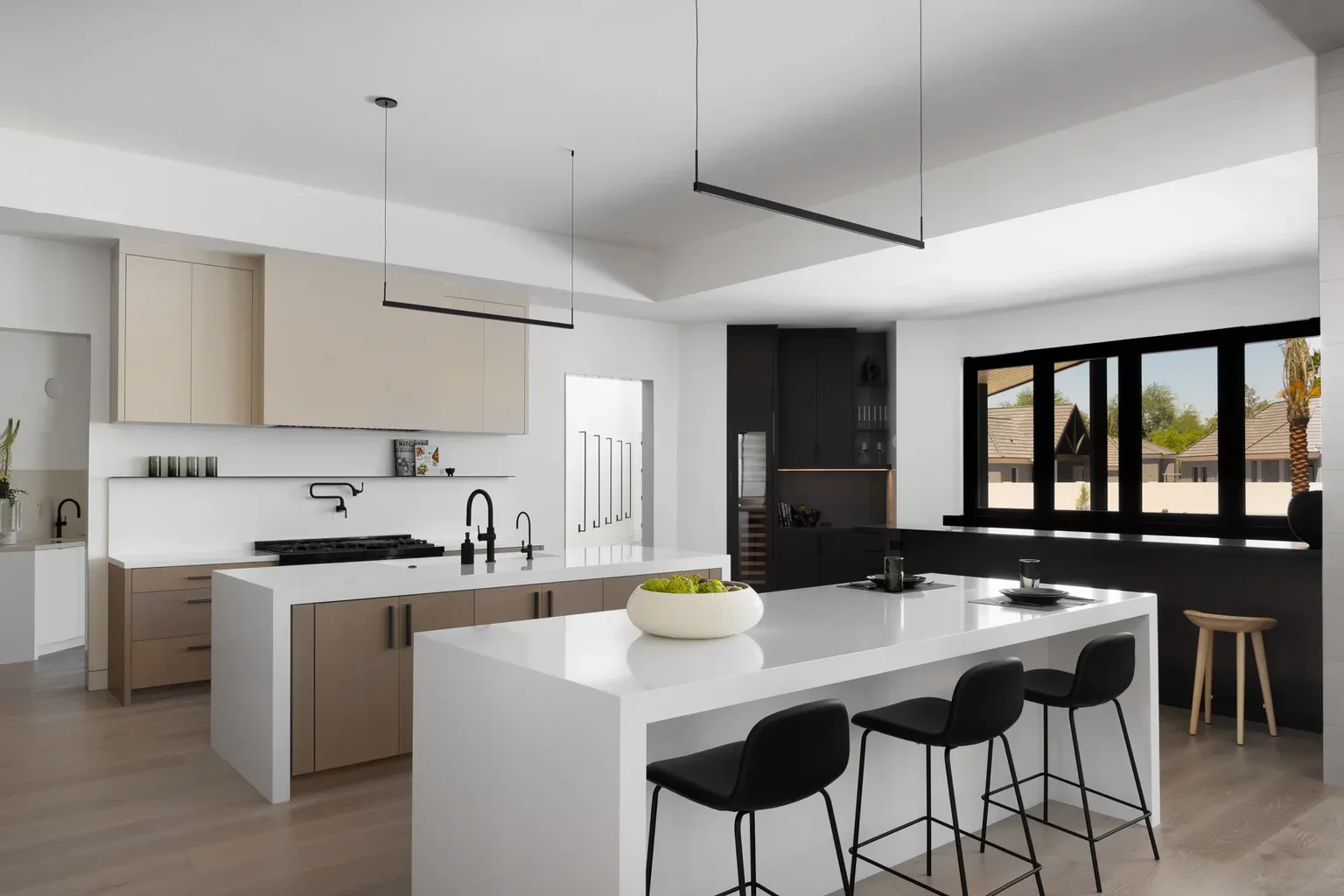 Modern kitchen with white island, black stools, and neutral cabinets