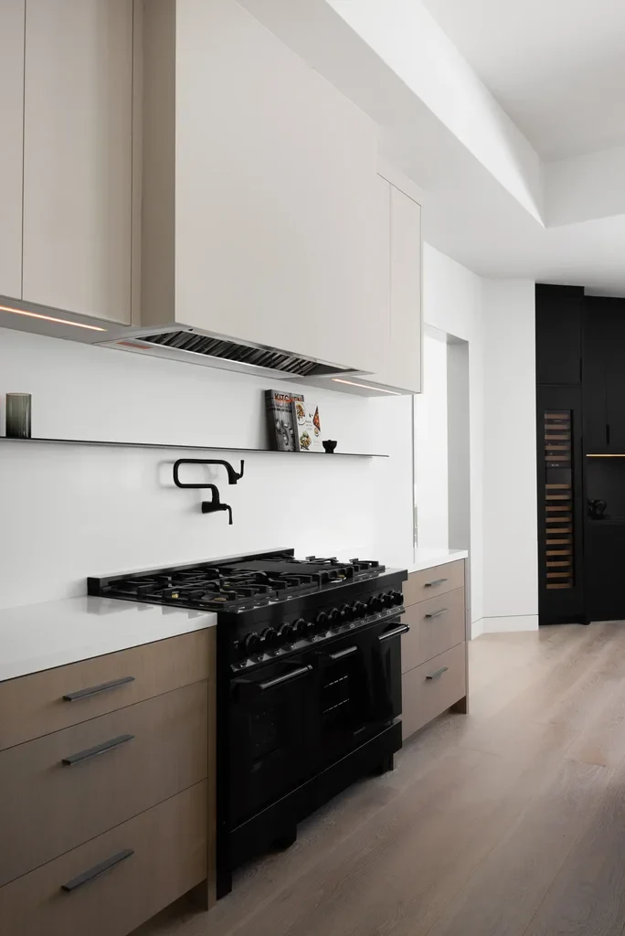 Modern kitchen with black range stove and beige cabinetry