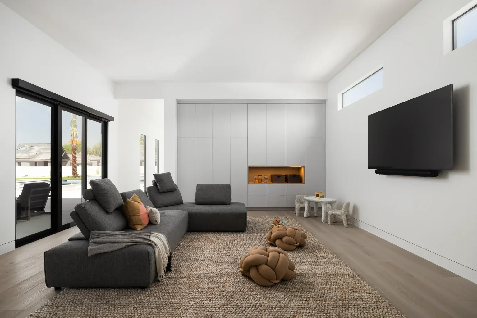 Modern minimalist living room with gray sectional sofa and TV