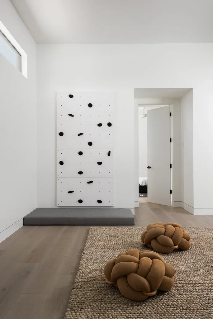 Minimalist room with indoor climbing wall and knot pillows