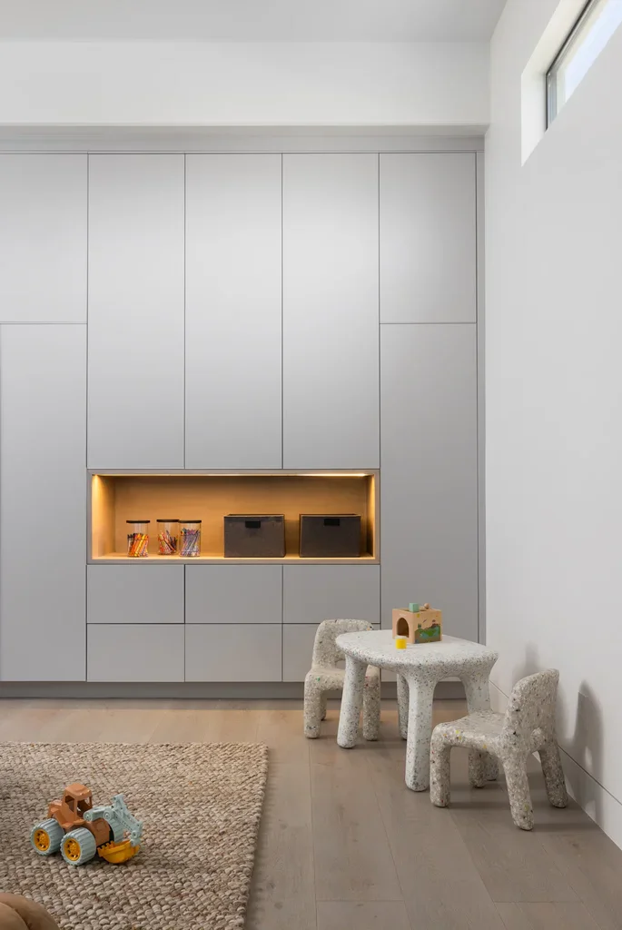 Modern children's playroom with built-in gray cabinets and small table