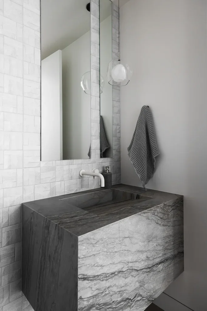 Modern bathroom with gray marble sink and white tile walls