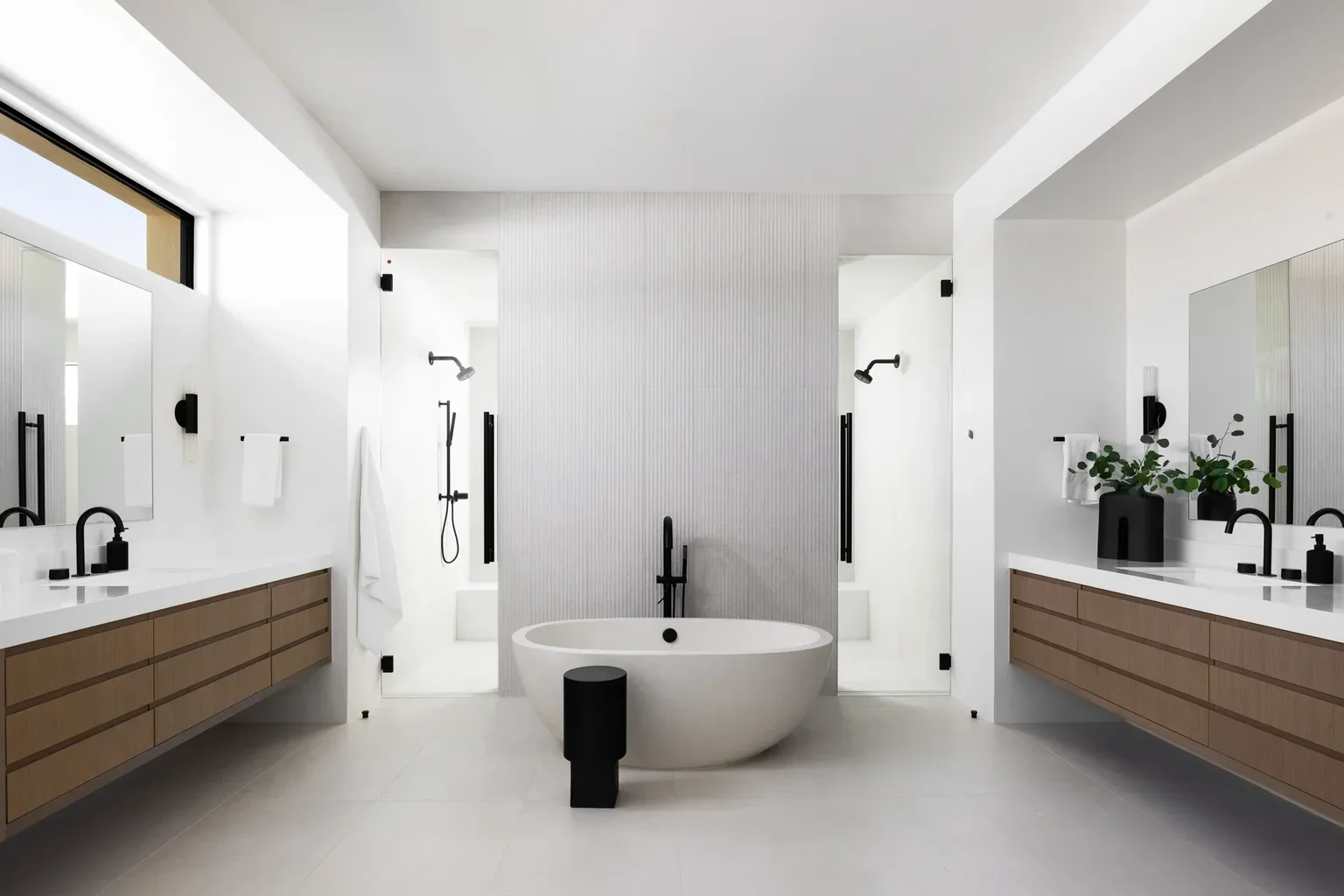Modern white bathroom with freestanding tub and dual vanities