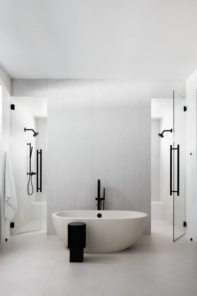 Modern white bathroom with freestanding tub and black fixtures