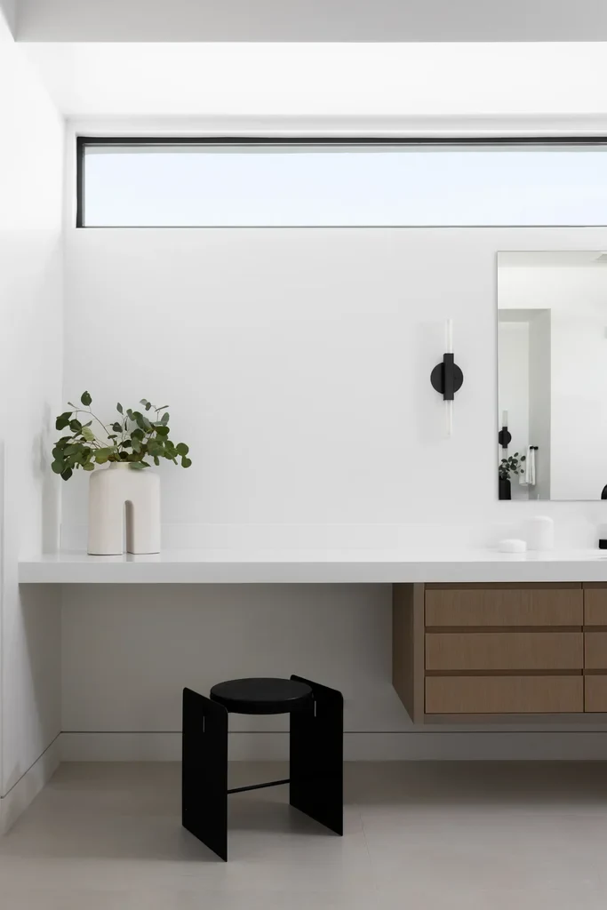 Modern minimalist bathroom with floating vanity and black stool