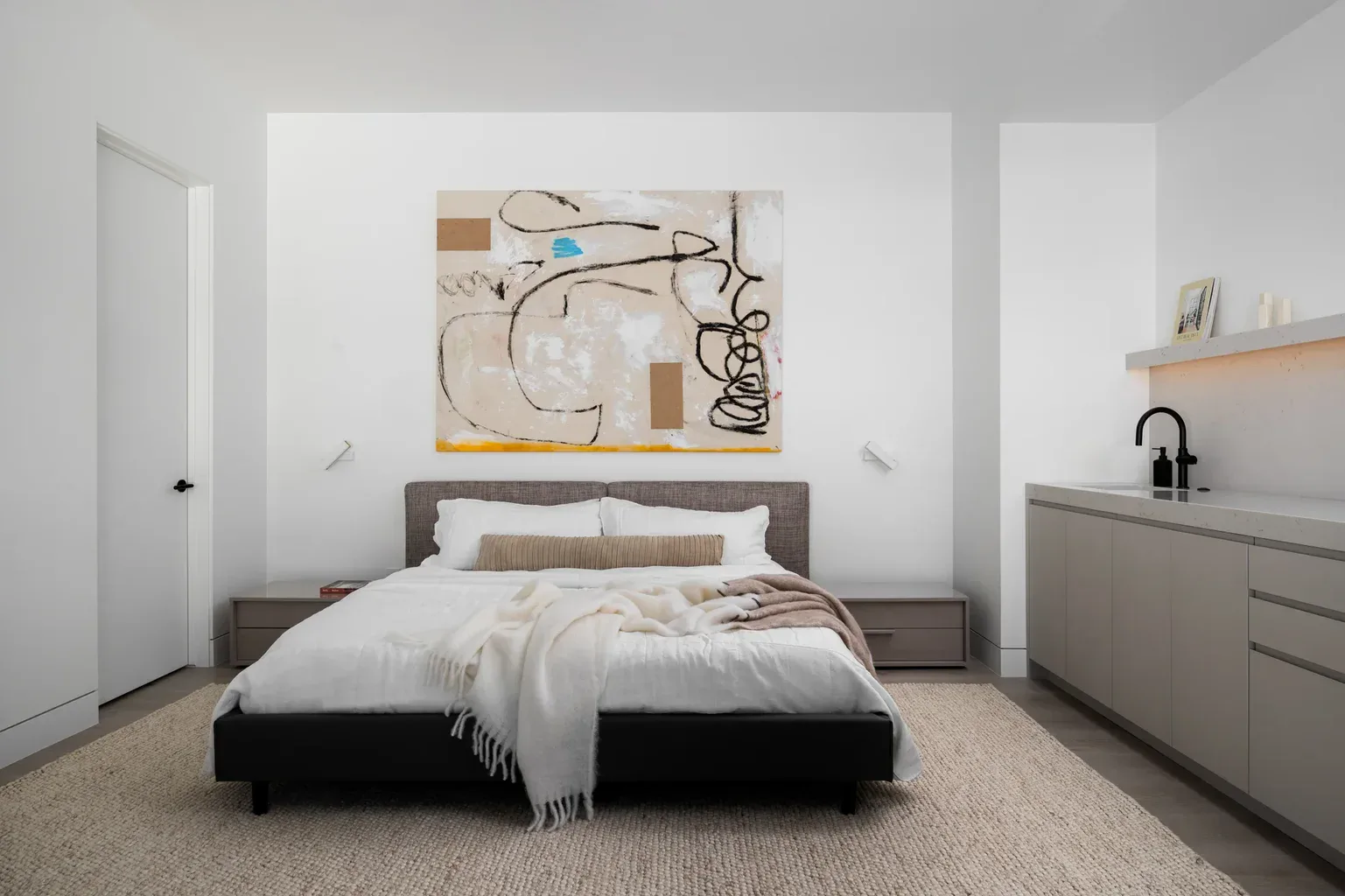 Modern minimalist bedroom with abstract wall art above bed