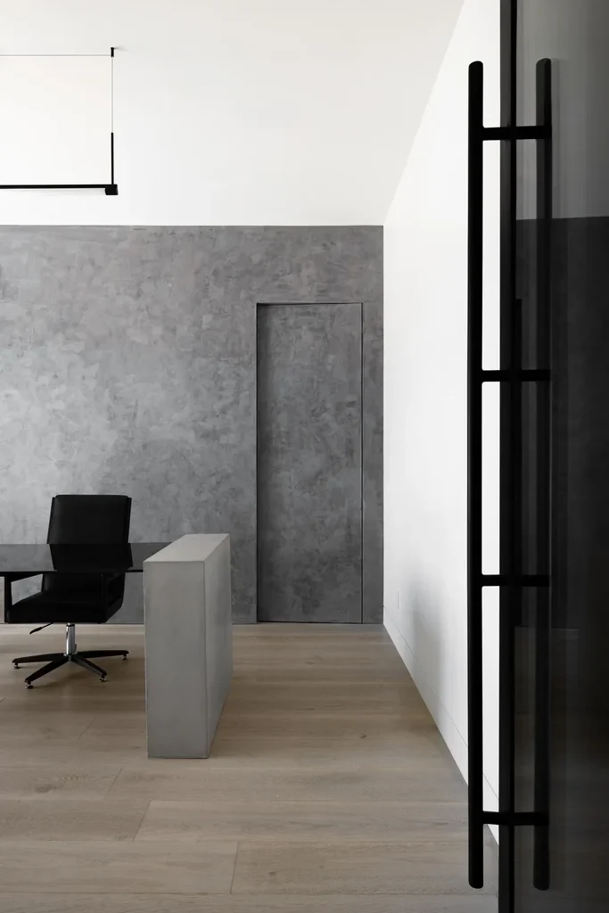 Minimalist office interior with concrete walls and black chair