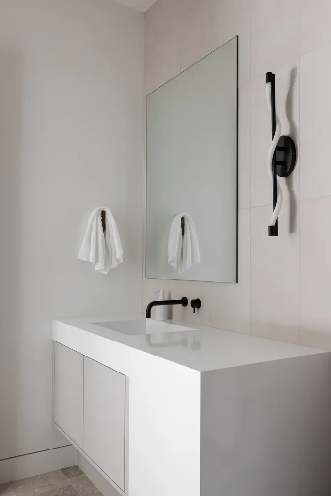 Modern minimalist white bathroom with black fixtures and mirror