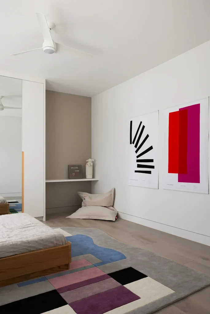 Modern bedroom with colorful abstract art prints and geometric rug