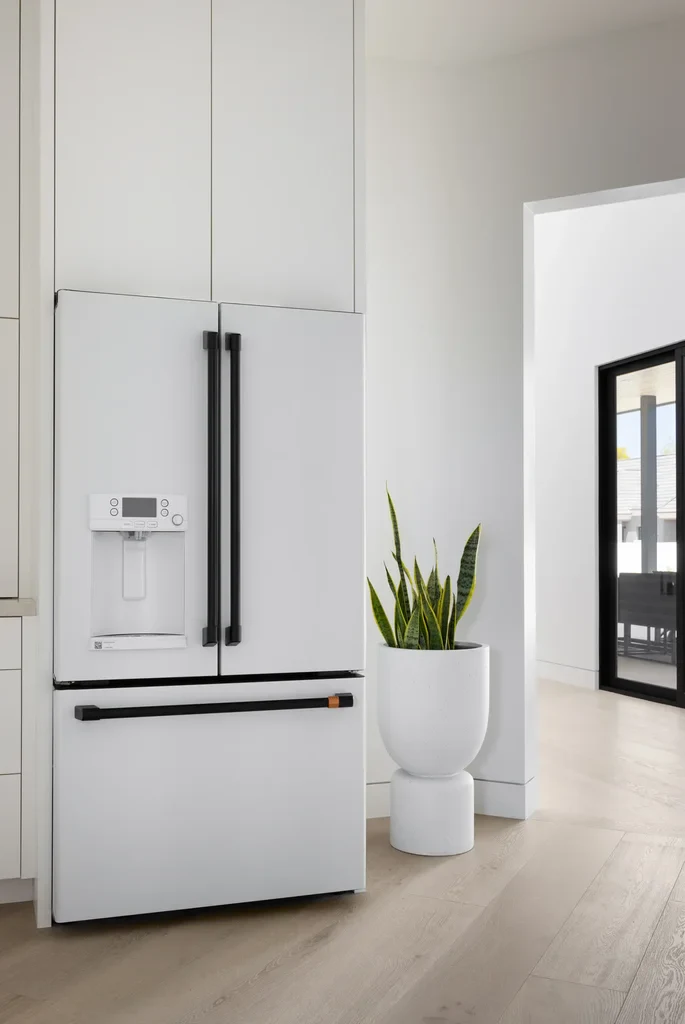 Modern white French door refrigerator with black handles in kitchen