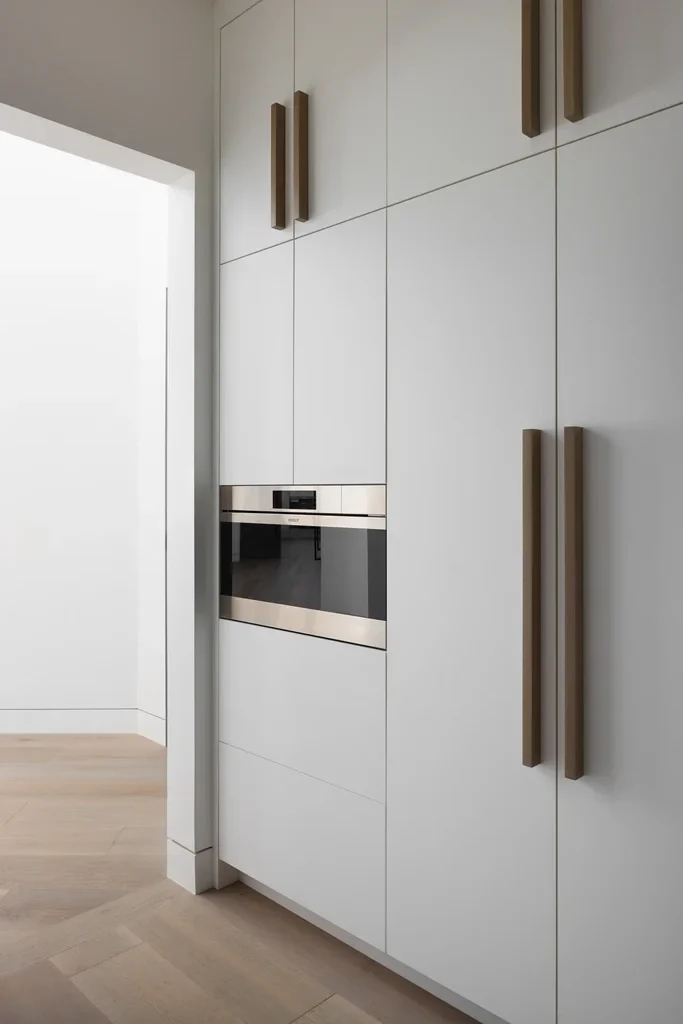 Modern minimalist kitchen with white cabinets and built-in oven