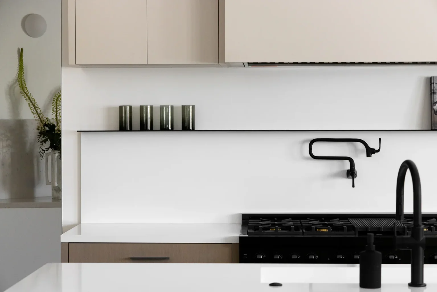 Modern minimalist kitchen with black fixtures and neutral cabinets