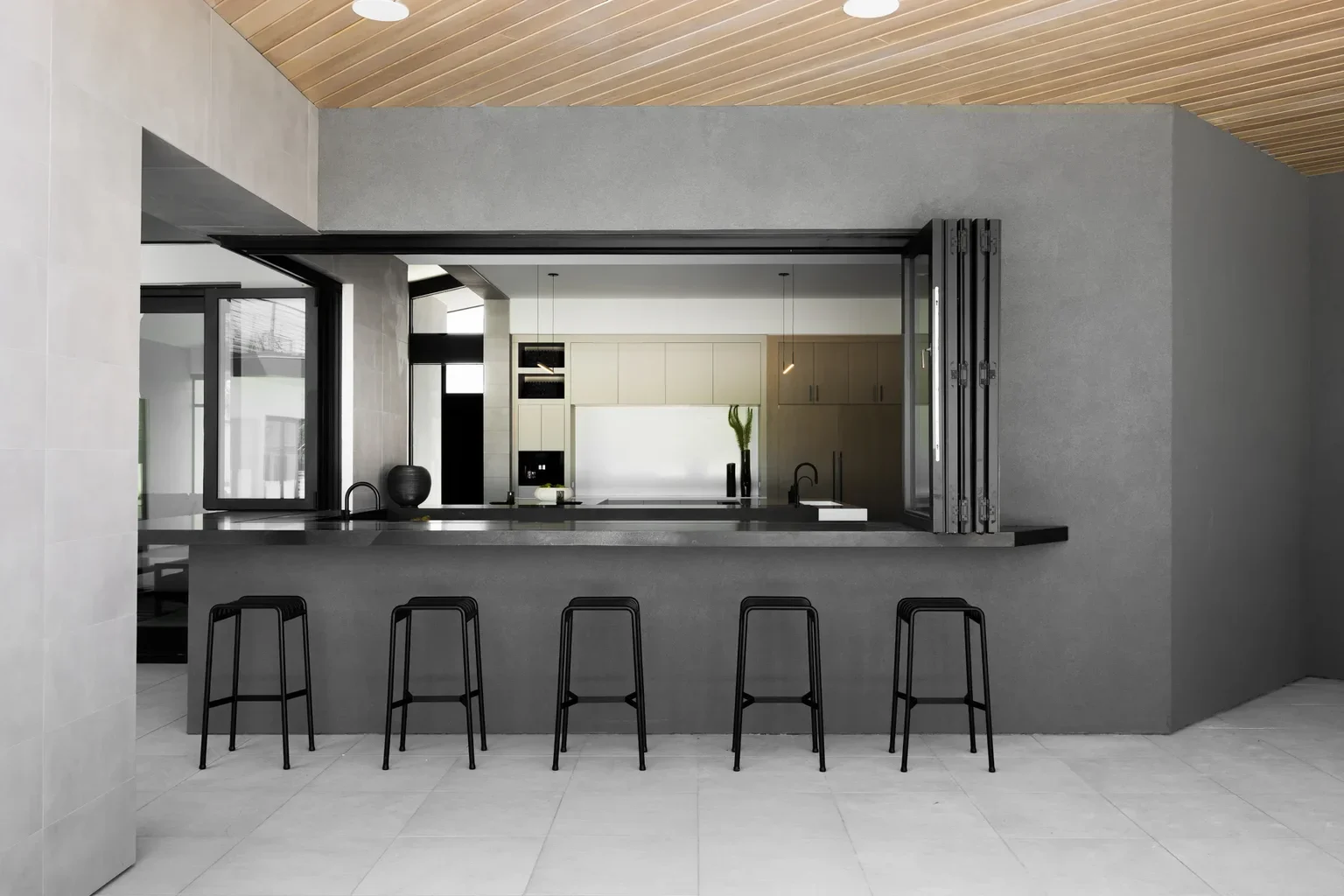 Modern kitchen pass-through window with black bar stools