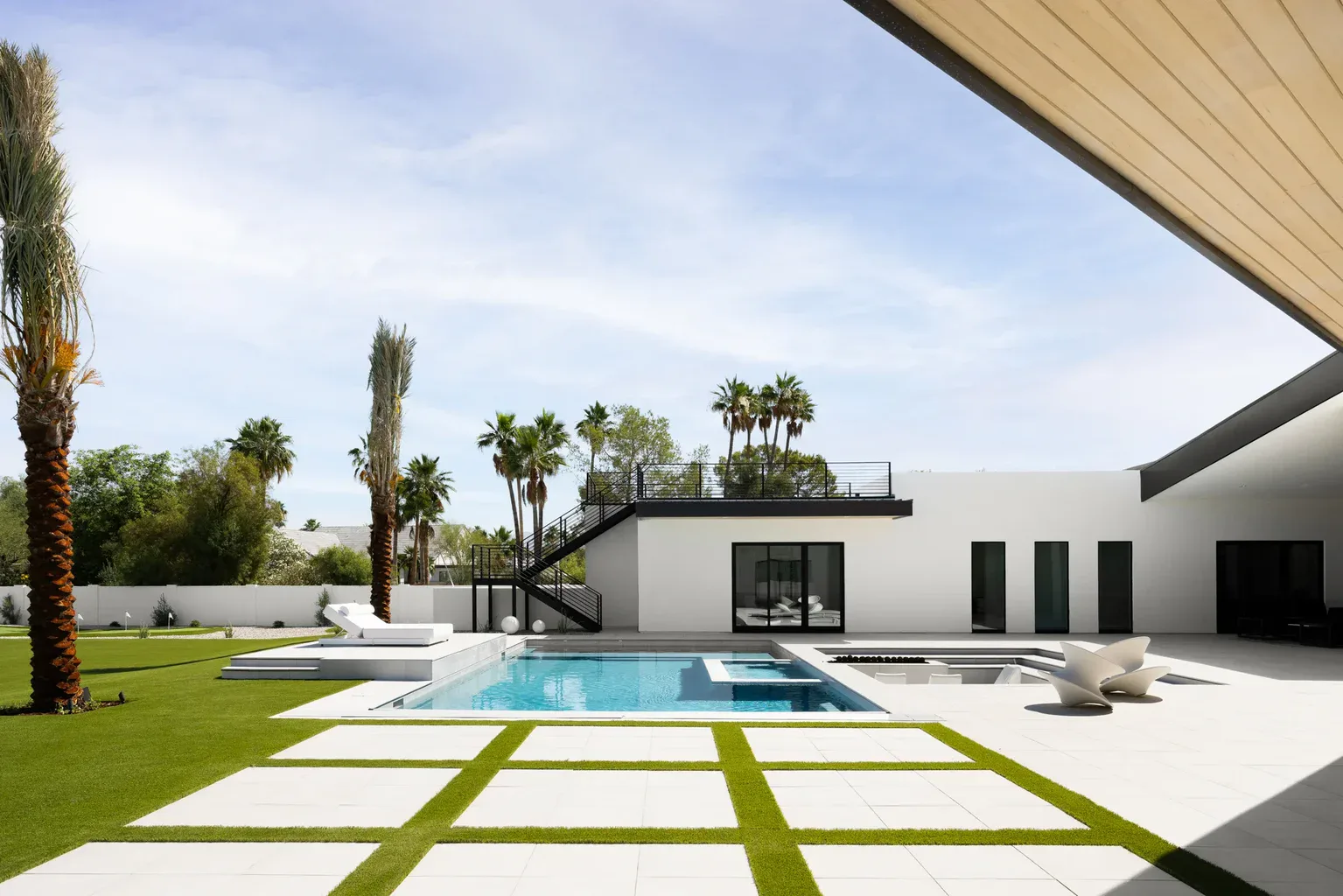 Modern luxury home backyard with pool and palm trees
