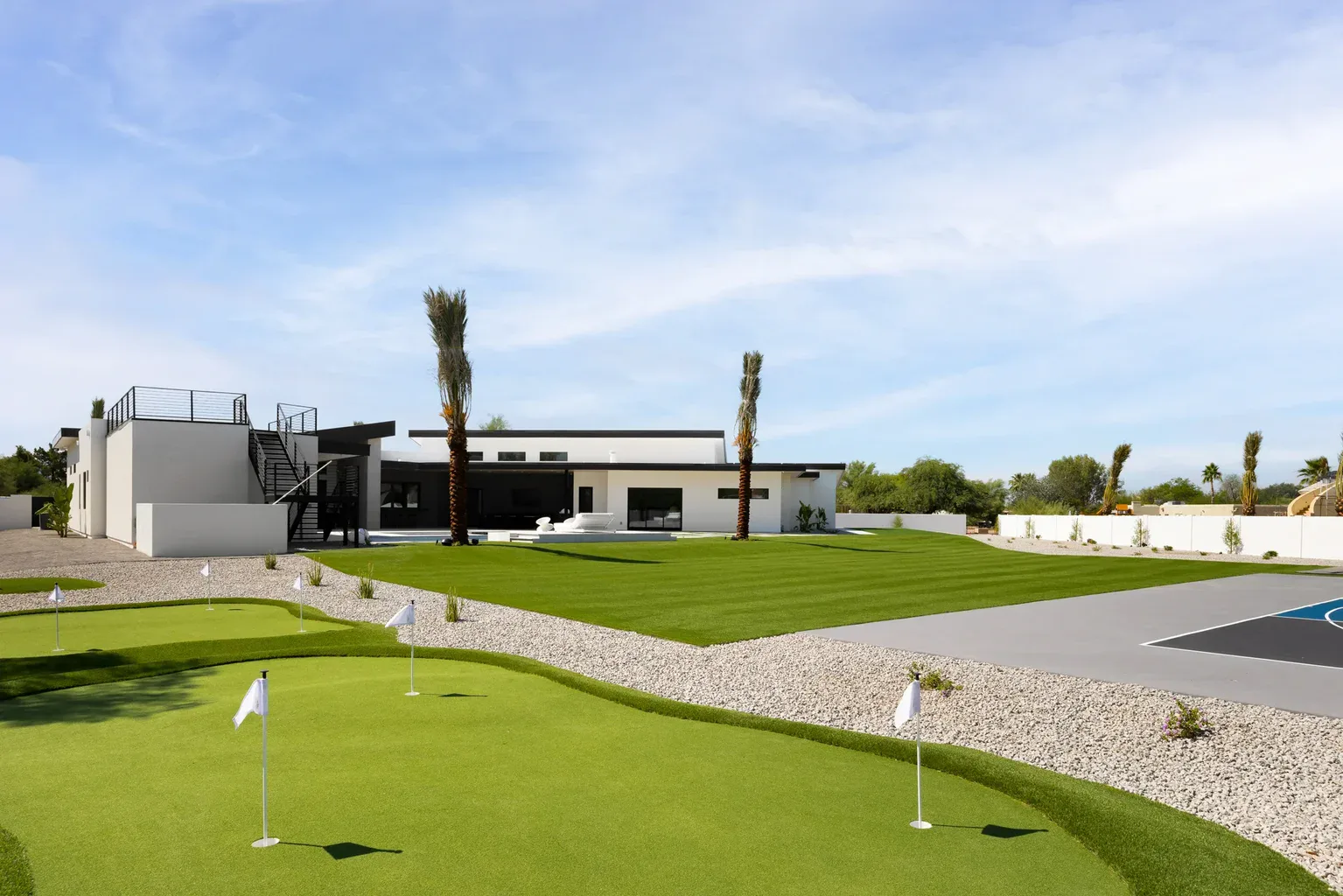 Modern luxury home with private putting green and palm trees