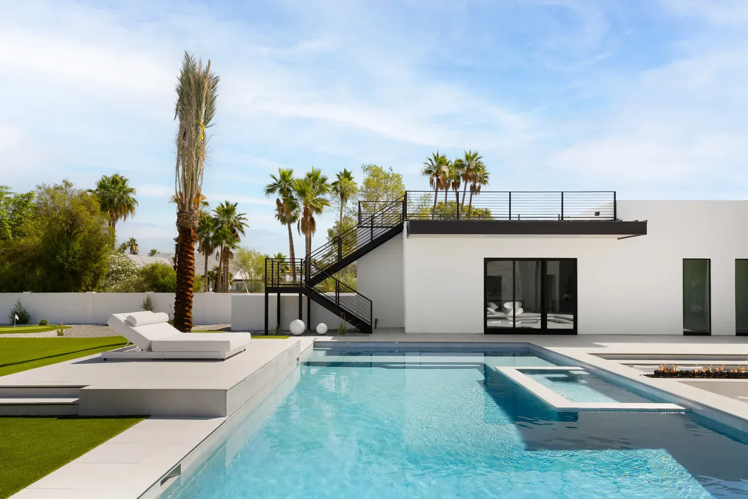 Modern luxury home with pool, rooftop deck, and palm trees
