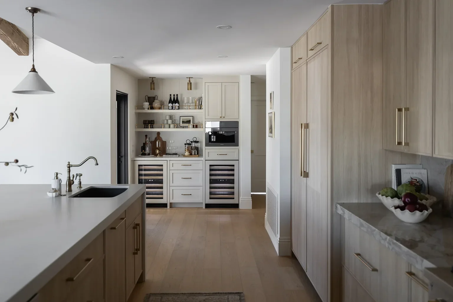 Elegant kitchen with wood cabinets, brass hardware, and wine coolers