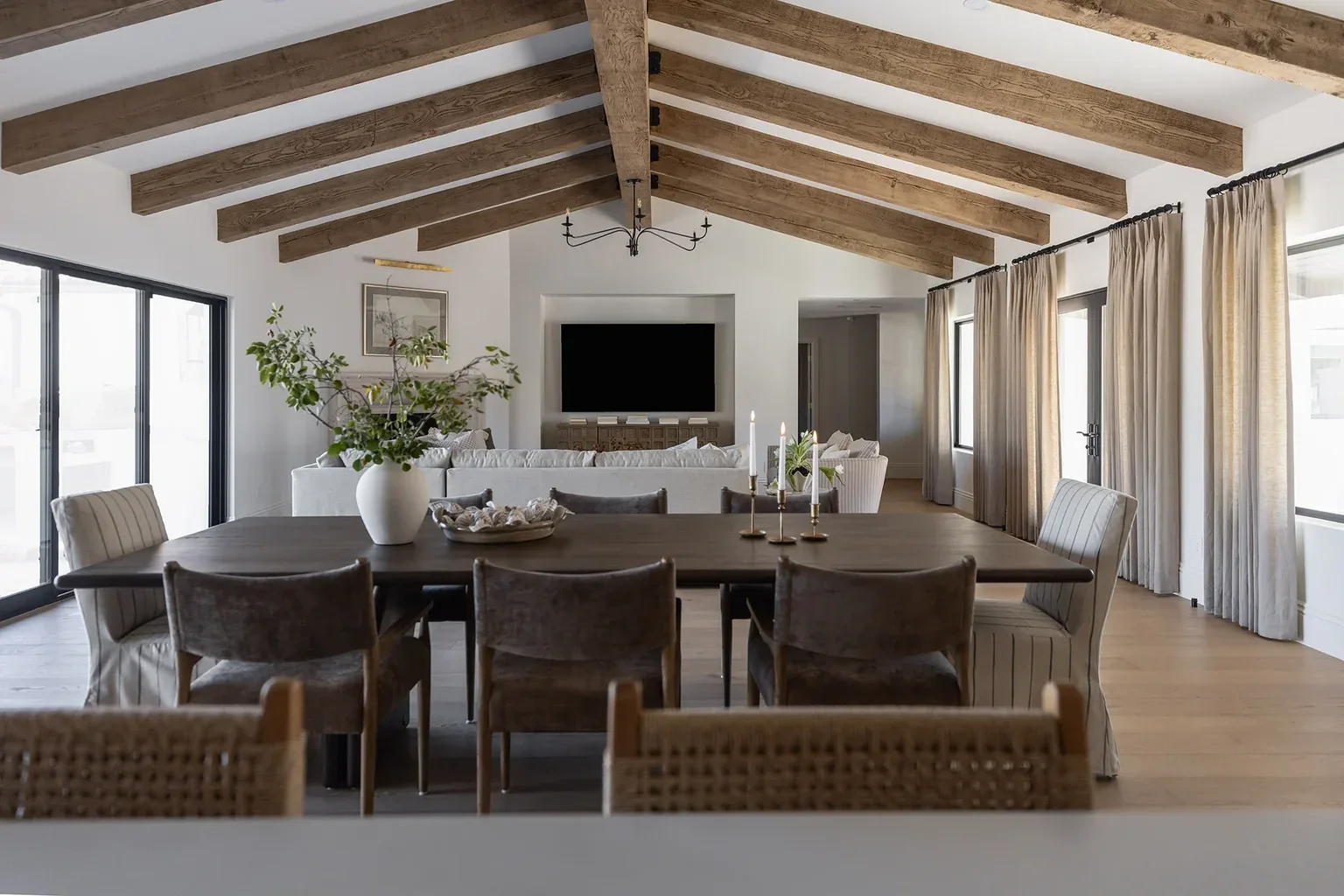 Open-plan dining and living room with vaulted wooden beam ceiling