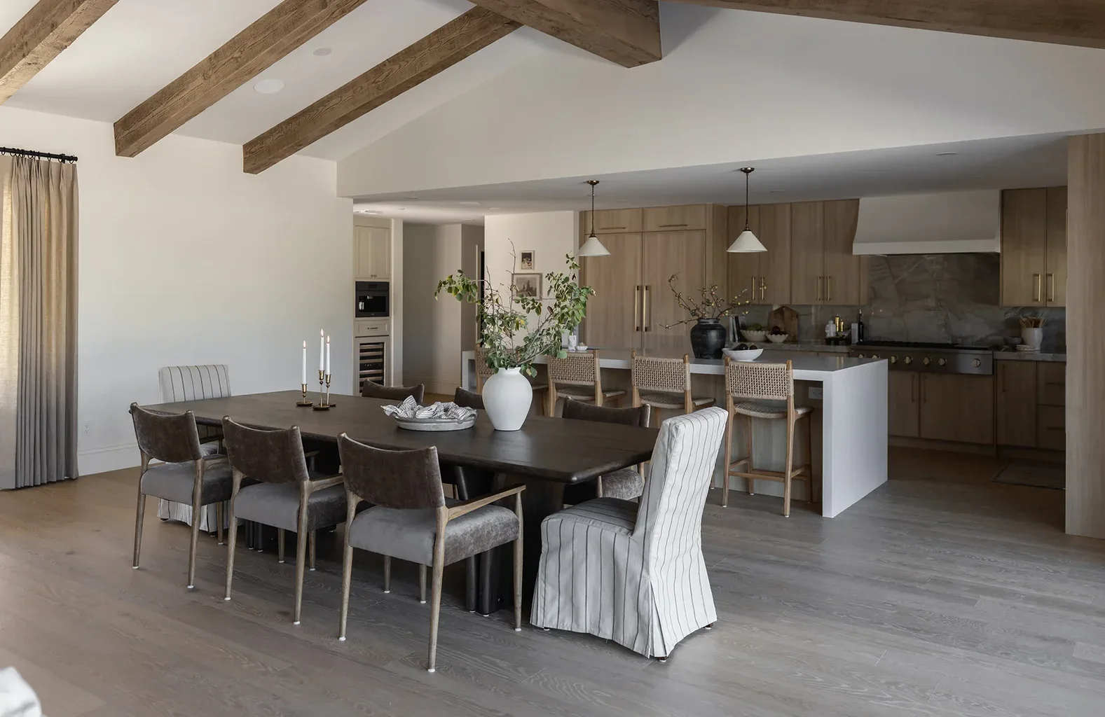 Open-concept dining room and kitchen with wood beam ceiling