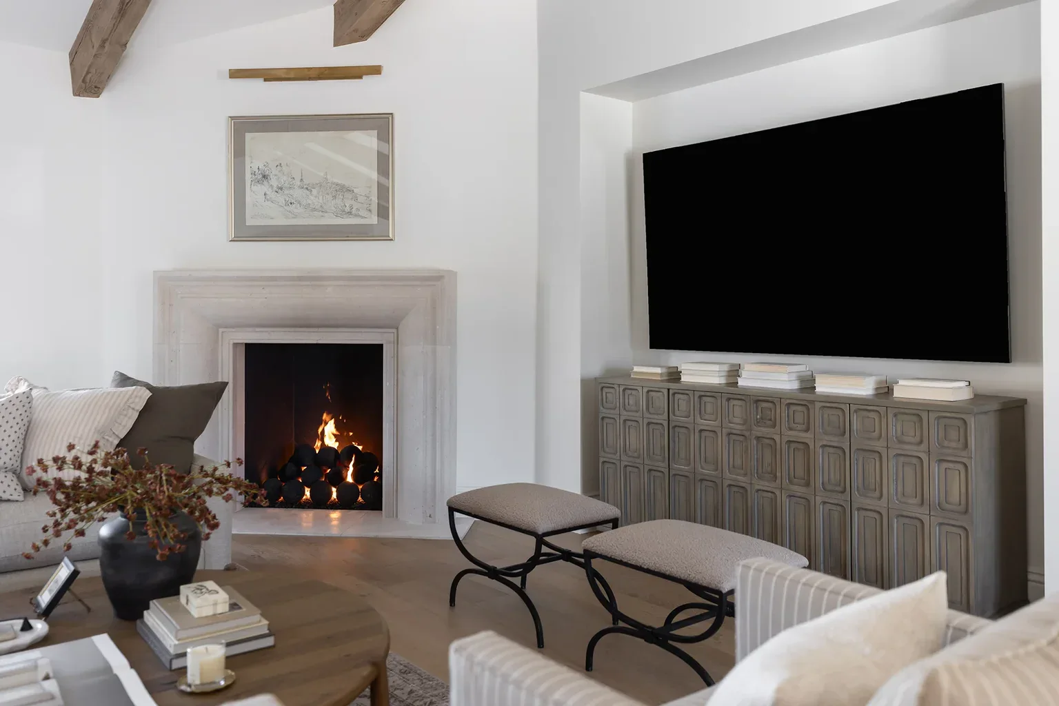 Elegant living room with fireplace, TV, and wooden beams