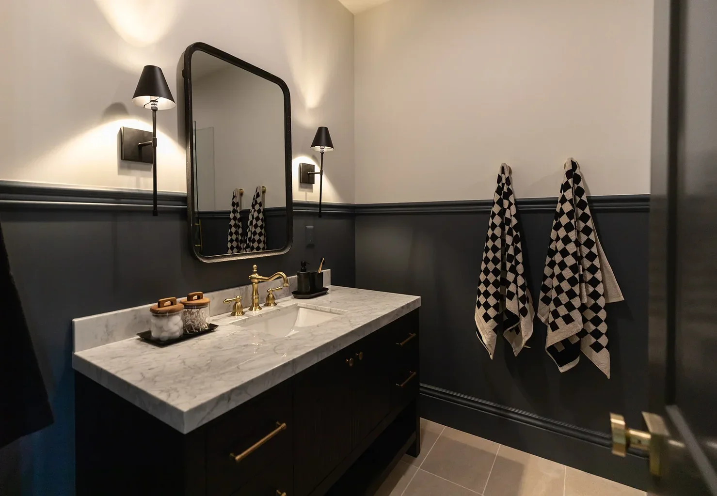 Elegant bathroom with dark walls, marble vanity, and gold fixtures