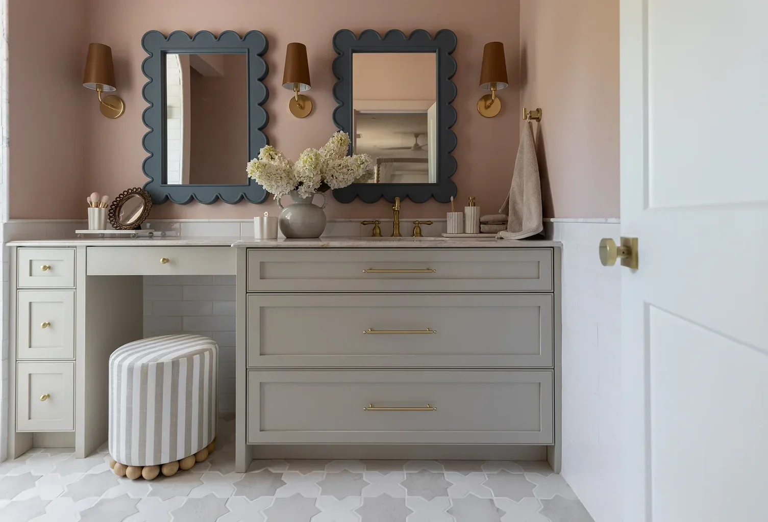 Elegant bathroom vanity with scalloped mirrors and pink walls