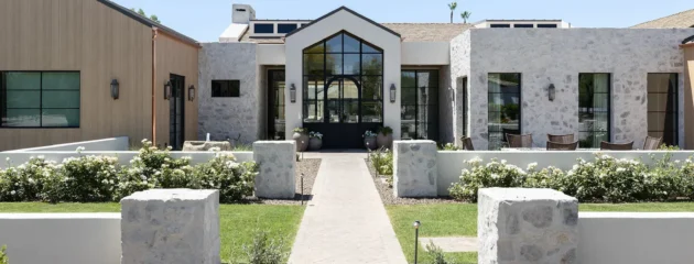 Modern stone resort entrance with manicured garden and pathway