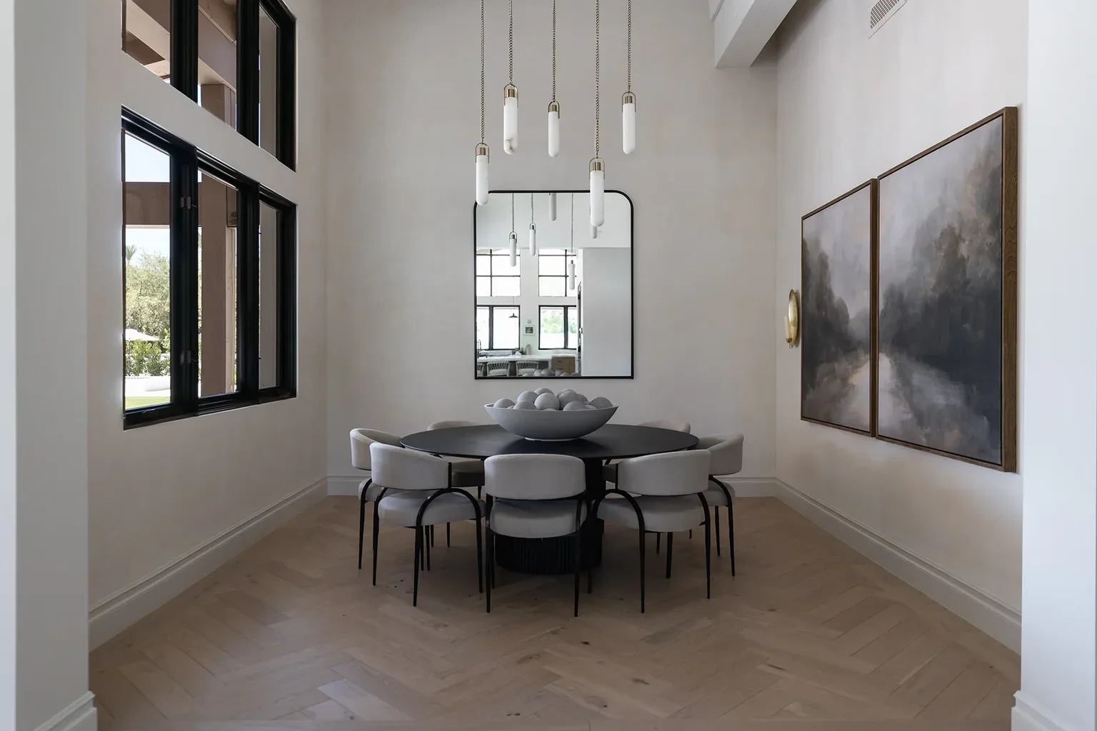 Modern dining room with round black table and pendant lights